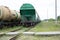 Two trains with carriages stand on the railway crossing. Cargo wagons and tank cars on the rails close-up