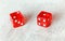 Two translucent red craps dices on white board showing Ace Deuce number 2 and 1
