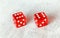Two translucent red craps dices on white board showing Boxcars or Midnight double number 6