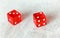 Two translucent red craps dices on white board showing Fever Five Little Phoebe number 3 and 2