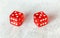 Two translucent red craps dices on white board showing Hard Ten number 5 twice