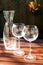 Two transparent shiny empty wineglasses and carafe in rays of sunlight.