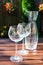 Two transparent shiny empty wineglasses and carafe in rays of sunlight.