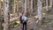 Two travel hikers with backpack walking while looking the landscape in the forest. Back view.