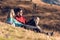 Two travel hikers enjoying the nature while looking the landscape and sitting in the mountain