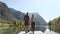 Two travel hikers in love enjoying the nature while looking the landscape in front of the lake in mountain.