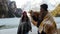 Two traveling young women covered in the blankets walking near the frozen lake