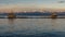 Two trebuchet fishing huts against the Alps covered with snow at sunset, Marina di Pisa, Tuscany, Italy