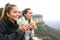 Two trekkers drinking and contemplating in a cliff