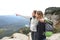 Two trekkers in the top of a cliff pointing away