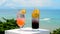 Two tropical fresh iced mocktails on the bar table with sea beach on background