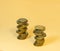 Two turrets made of coins. Scattering of coins on a beige background