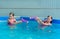 Two tween caucasian girls with water guns toy fight game in pool