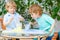 Two twin boys making experiment with colorful bubbles