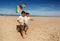 Two twin boys run with kite on the sea beach