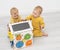 Two twin boys toddler playing with busy board at home. Developing games for children.