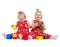 Two twin girls in red dresses playing with blocks