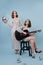 Two twin sisters at a party, guitar in their hands