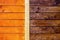 Two types of wooden wall processing: painted orange and treated with brown stain close-up background