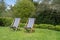 Two typical english deckchairs on lawn in garden