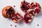 Two uncovered pomegranates on the white table