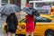Two undefined elegant dressed women hailing a taxi cab under heavy rain in New-York