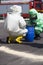 Two unidentifiable men in protective gear cleaning up after chemical disaster