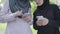 Two unrecognizable Muslim women using smartphones on sunny day outdoors. Confident female friends in hijabs surfing