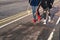 Two unrecognizable teenage girls carrying skateboards walking along a cycle path.