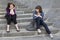 Two urban teen girl sitting on stairs