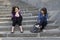 Two urban teen girls sitting on stairs