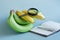Two varieties of bananas, magnifier, pen and notepad on light background. Examination of the quality bananas.