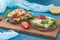 Two vegeterain danish open sandwiches, one with grilled zucchini and garden radish, the other with blue cheese, strawberry and