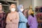 two veiled business women wearing masks with their arms crossed as they stand back to back