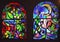 Two vertical stained glass windows with abstract background of multicolored glass with floral and fruit ornaments