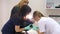 Two veterinarians of the girl prepare the dog for surgery in a veterinary clinic.The dog is anesthetized on the