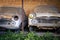 two Vintage cars left standing and falling apart in a shelter