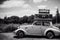 Two vintage cars with suitcases on car roof driving on road