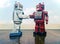 Two vintage robot shake hands on a old wooden floor