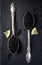 Two vintage silver spoons with black sturgeon caviar on black slate stone background. Top view, flat lay