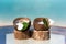 Two virgin coconuts with juice on the glass table at the beach with ocean