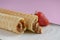 Two waffle cones with sweet boiled condensed milk in white plate on pastel pink background. Condensed tubules.