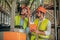 Two warehouse workers in helmets having a work conversation