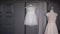 Two wedding dresses, white bridal gown hanging on hanger in bedroom. Bride veil.