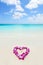 Two wedding rings in a heart lei on beach vacation