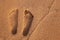 Two well-shaped human footprints in the sand