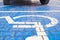 Two wheels on the disabled dedicated parking place marked with blue wheel chair symbol