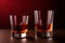 Two whiskey glasses with melting ice in them with a red background generated by ai