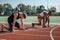 Two white and black athletes at the start of the stadium