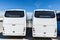 Two white buses parked at the port